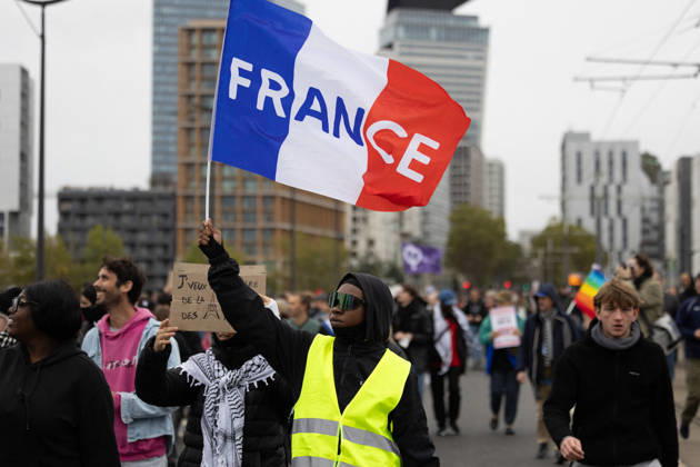 Yellow Vests Protest Act II - Paris RL A woman wearing a Yellow Vest (Gilet Jaune) holds a French flag during a demonstration in favor of purchasing power, the protection of public services, and fiscal and social justice, in Paris on October 24, 2026 as part of a nationwide call for mobilisation and protest bringing together former members of the Yellow Vest movement, labor unions, high school and university students. Photo by Raphael Lafargue ABACAPRESS.COM Paris France  Copyright: xLafarguexRaphael ABACAx