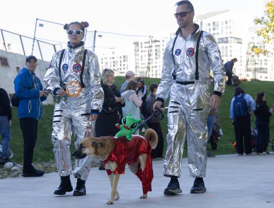 (261025) -- TORONTO, Oct. 25, 2026 -- A dog and its owners take part in Howl oween at the Bentway, a dog-and-owner costume contest, in Toronto, Canada, on Oct. 24, 2026. The annual event was held here on Saturday, bringing Halloween fun for dogs and their owners. (Photo by Xinhua) CANADA-TORONTO-HOWL OWEEN-DOG & OWNER COSTUME CONTEST ZouxZheng 