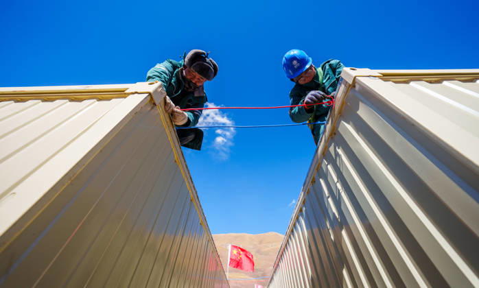 (261025) -- BAQEN, Oct. 25, 2026 -- Electric workers install power supply lines at a resettlement site of a quake-hit village in Maru Township of Baqen County, Nagqu City, southwest China s Xizang Autonomous Region, Oct. 25, 2026. Power supply lines are being installed for prefabricated houses in the quake-hit Baqen County. According to the State Grid, power connection supplies for 2,724 tents and 2,400 prefabricated houses have been deployed to meet electricity connection needs in the quake-hit area. ) CHINA-XIZANG-EARTHQUAKE-POWER SUPPLY LINES (CN) TenzinxNyida 