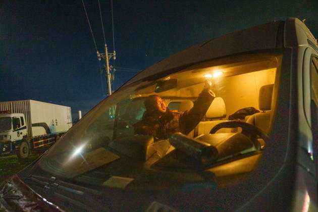 (261025) -- BAQEN, Oct. 25, 2026 -- Du Guoping prepares to rest inside a vehicle after a full day s work at a temporary shelter in Maru Township of Baqen County, Nagqu City, southwest China s Xizang Autonomous Region, Oct. 24, 2026. After a 7.0-magnitude earthquake struck Baqen County in Nagqu, southwest China s Xizang Autonomous Region, on Thursday, Du Guoping, owner of a dumpling restaurant in Xigaze, postponed the opening of his two new restaurants and headed to the disaster zone with his staff. It took only about 10 minutes to make the decision that we would go to Baqen and cook dumplings for earthquake-affected residents, Du said. The team loaded more than 1,500 kilograms of dumplings onto vehicles and set off from Xigaze at mid