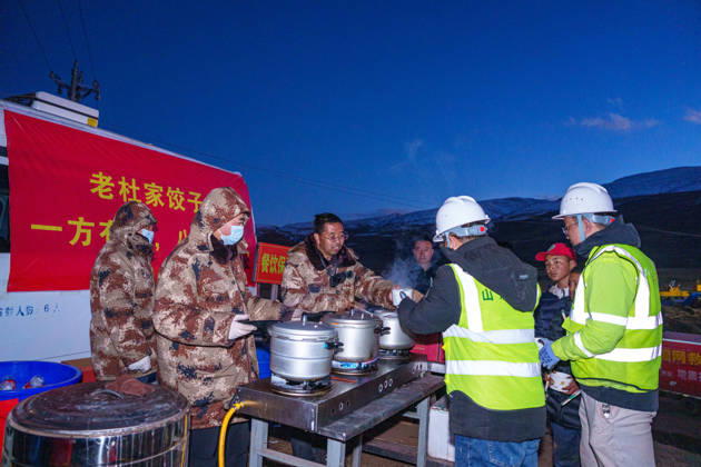 (261025) -- BAQEN, Oct. 25, 2026 -- Du Guoping (3rd L) distributes dumplings to rescuers at a temporary shelter in Maru Township of Baqen County, Nagqu City, southwest China s Xizang Autonomous Region, Oct. 24, 2026. After a 7.0-magnitude earthquake struck Baqen County in Nagqu, southwest China s Xizang Autonomous Region, on Thursday, Du Guoping, owner of a dumpling restaurant in Xigaze, postponed the opening of his two new restaurants and headed to the disaster zone with his staff. It took only about 10 minutes to make the decision that we would go to Baqen and cook dumplings for earthquake-affected residents, Du said. The team loaded more than 1,500 kilograms of dumplings onto vehicles and set off from Xigaze at midnight on the nig