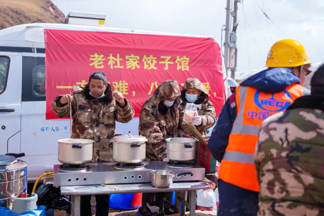 (261025) -- BAQEN, Oct. 25, 2026 -- Du Guoping (L) cooks dumplings at a temporary shelter in Maru Township of Baqen County, Nagqu City, southwest China s Xizang Autonomous Region, Oct. 24, 2026. After a 7.0-magnitude earthquake struck Baqen County in Nagqu, southwest China s Xizang Autonomous Region, on Thursday, Du Guoping, owner of a dumpling restaurant in Xigaze, postponed the opening of his two new restaurants and headed to the disaster zone with his staff. It took only about 10 minutes to make the decision that we would go to Baqen and cook dumplings for earthquake-affected residents, Du said. The team loaded more than 1,500 kilograms of dumplings onto vehicles and set off from Xigaze at midnight on the night of the earthquake.