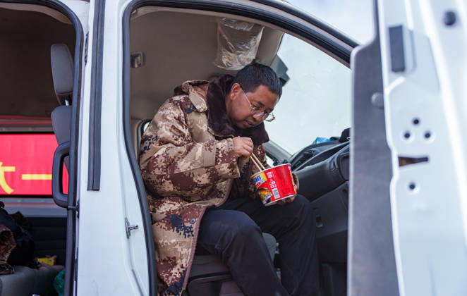 (261025) -- BAQEN, Oct. 25, 2026 -- Du Guoping eats instant noodles at a temporary shelter in Maru Township of Baqen County, Nagqu City, southwest China s Xizang Autonomous Region, Oct. 24, 2026. After a 7.0-magnitude earthquake struck Baqen County in Nagqu, southwest China s Xizang Autonomous Region, on Thursday, Du Guoping, owner of a dumpling restaurant in Xigaze, postponed the opening of his two new restaurants and headed to the disaster zone with his staff. It took only about 10 minutes to make the decision that we would go to Baqen and cook dumplings for earthquake-affected residents, Du said. The team loaded more than 1,500 kilograms of dumplings onto vehicles and set off from Xigaze at midnight on the night of the earthquake.